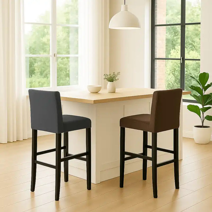 Deux chaises de bar, l’une gris anthracite et l’autre marron chocolat, sont disposées autour d’une table haute élégante.