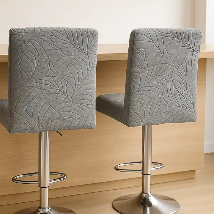 Deux chaises de bar recouvertes de housses en jacquard gris 