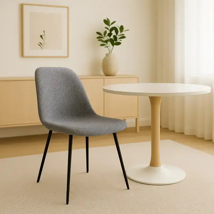 Chaise design en jacquard gris clair, dans un intérieur minimaliste et lumineux avec une table ronde élégante et un tapis beige, ambiance moderne et raffinée.