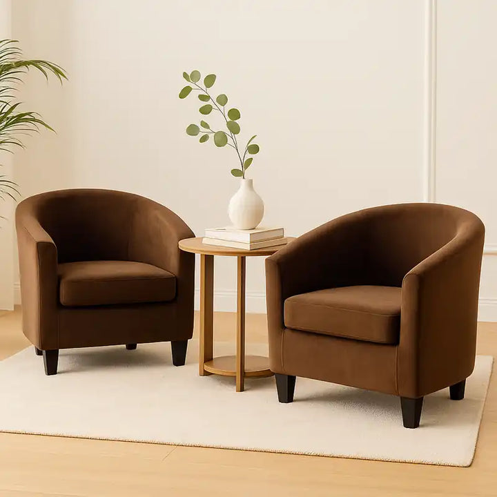 Deux fauteuils crapauds en velours marron clair sont disposés dans un salon minimaliste et lumineux.