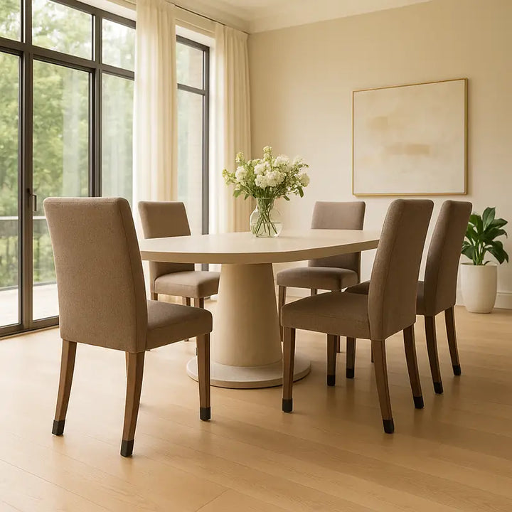 Table ovale beige au centre. Les pieds des chaises portent des protege-pieds noirs visibles.